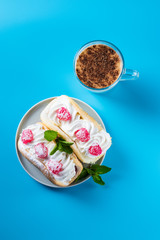 Obraz na płótnie Canvas Air cake with raspberries on a saucer. Kefir with cinnamon, fermented drink. Blue background