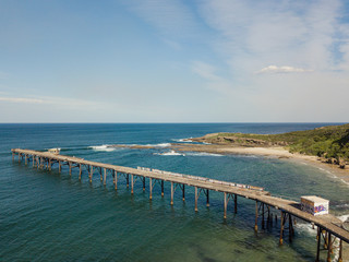 Obraz premium View of a jetty on the coastline during the day.