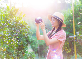 Young girl holding film camera with beautiful orange field background in vacation time ,people with landscape concept