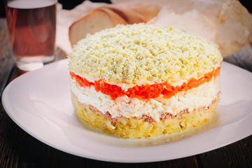 Traditional Russian salad Mimosa on dark boards