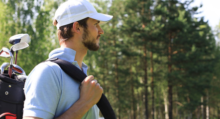 Obraz premium Golf player walking and carrying bag on course during summer game golfing.