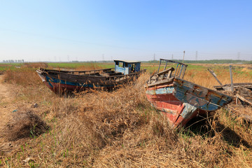 Fototapeta premium The broken wooden boat is on land