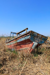 Fototapeta premium The broken wooden boat is on land