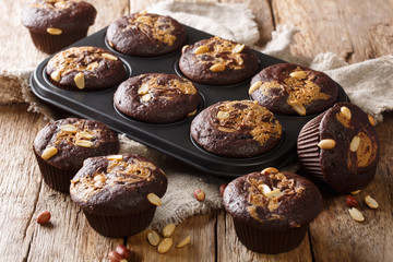 delicious breakfast of chocolate muffins with peanut butter and nuts in a baking dish on the table. horizontal