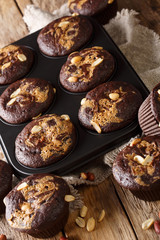 Chocolate peanut muffins in a baking dish on the table. vertical