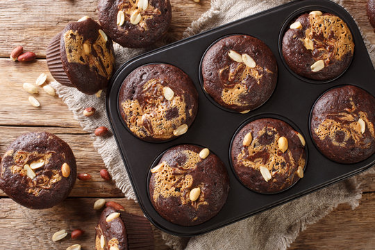 Delicious Breakfast Of Chocolate Muffins With Peanut Butter And Nuts In A Baking Dish. Horizontal Top View