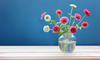 delicate bouquet with pink zinnias on a blue background.