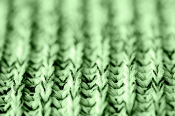 Knitted woolen texture close up. Textile background green color toned