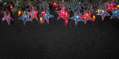 Warm star shaped light garlands, festive decorations with copy space. Christmas concept. Flat lay, top view