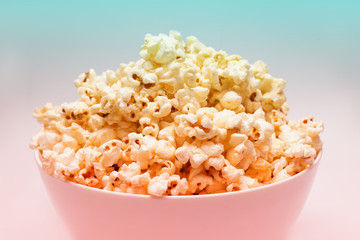 Popcorn in white big bowl isolated on white background with pastel color filter effect