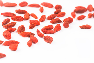 Spread out goji berries on a white background.