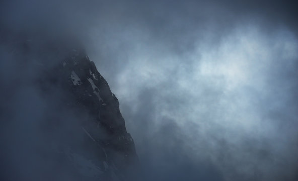 Rocky mountain face in dark clouds