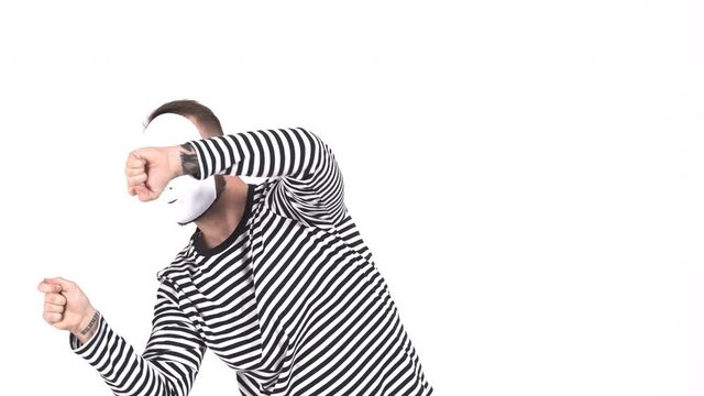 Funny male mime in white mask acting performance. One actor performing show on white background.