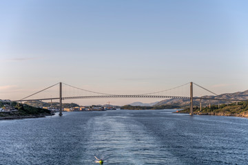 cruiser wake under high bridge on fjord, Rorvik, Norway