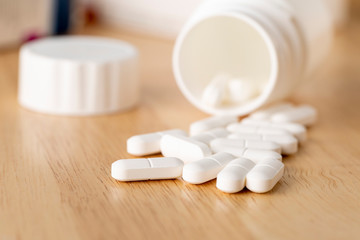 Fototapeta na wymiar Set of white pills are by the medicine bottle