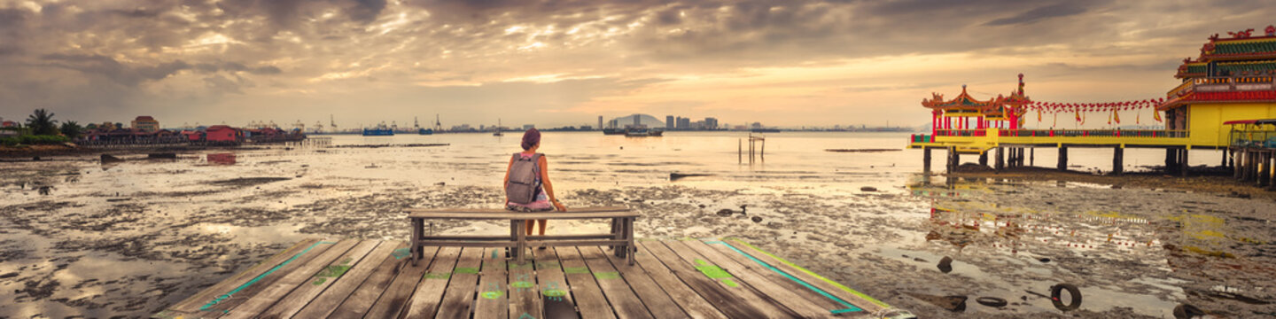 Tourist sitting at Yeoh jetty, Penang, Malaysia. Panorama