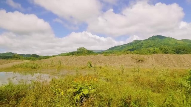River banks with strafe left drone video.  Swamp marshlands next to river crossing in Costa Rica.