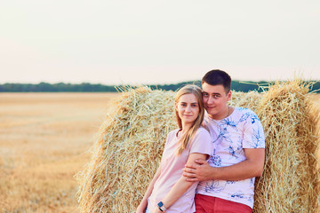 Happy couple in haystack field.