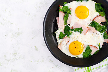 Fried eggs  with ham and spinach. Delicious English Breakfast. Brunch. Keto/paleo diet. Top view, overhead