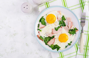 Fried eggs  with ham and spinach. Delicious English Breakfast. Brunch. Keto/paleo diet. Top view, overhead