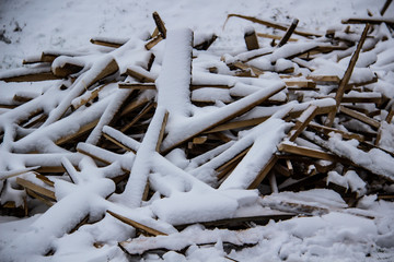 Firewood under the snow in the park. A winter day.