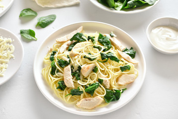 Spaghetti with spinach leaves, grilled chicken breast and cheese