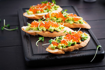 Sandwiches with salmon red caviar and salsa with avocado. Sandwich for lunch. Delicious food.