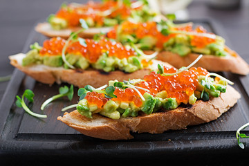 Sandwiches with salmon red caviar and salsa with avocado. Sandwich for lunch. Delicious food.