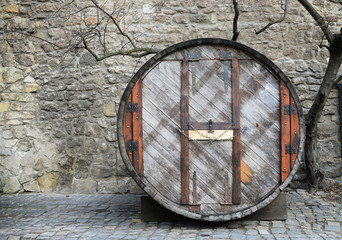 Great old wooden barrel near the stone wall