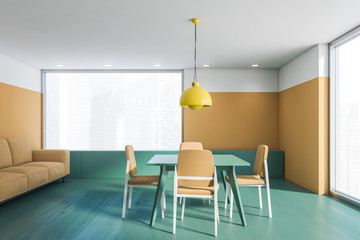 Beige and green dining room interior with sofa