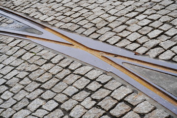 intersection of rusty rails in the old town on a road of cobblestones. transport network in the city, trams.