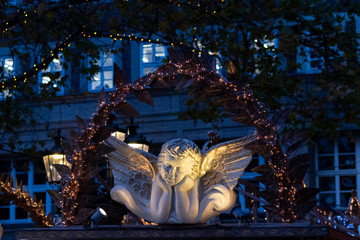 Romantisch beleuchteter Weihnachtsengel auf einem Weihnachtsmarkt mit goldenen Flügeln in der...