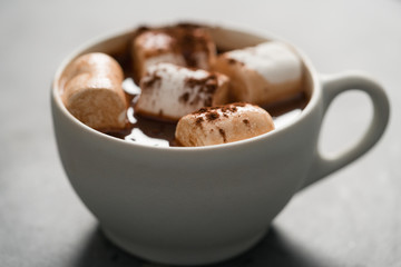 Cocoa drink with marshmallow in white cup on terrazzo surface