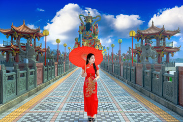 Beautiful women wearing dresses red cheongsam holding an umbrella walking on the bridge at Zuoying...