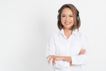 Call center operator woman short hair, wearing a white shirt with headset standing crossing her arms isolated on white background.