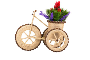 Fototapeta na wymiar A twine souvenir in the form of a tricycle with a basket of flowers.