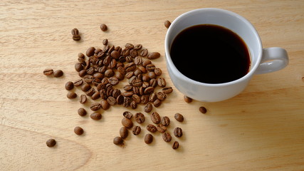 cup of coffee and beans on wooden background