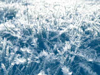 winter background with snowflakes crystals patterns and snow on frozen grass