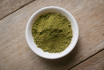 Stevia powder in white plate on wooden background.