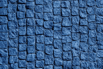 Top view on stone road close up. Old pavement of granite. Blue square cobblestone sidewalk.