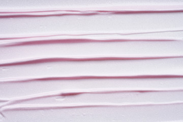Gently pink strokes and texture of face cream or acrylic paint isolated on white background
