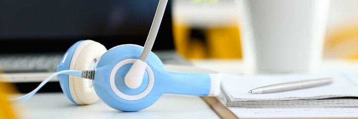 Empty remote office workplace with laptop and headset