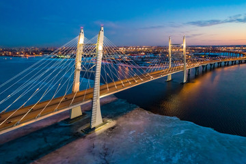 Saint Petersburg. Russia. Bridges Of St. Petersburg. Cable-stayed bridge over the Neva river. Movement of cars on the Obukhov bridge. Panorama of evening St. Petersburg. Gulf of Finland with ice.