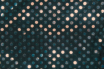 Abstract blurred of reflection from metallic dots on a black background.
