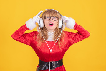 woman in santa claus costume and headphones isolated on color background