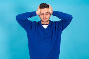 casual young man isolated on natural blue background