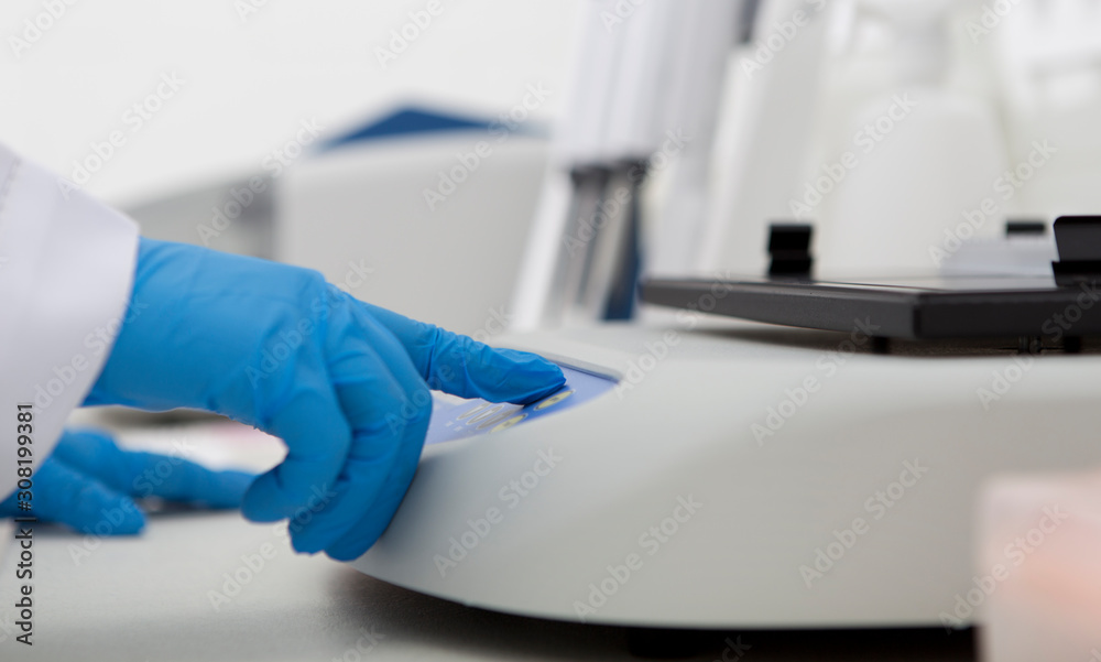 Poster Hands in latex gloves pushing buttons on lab machine