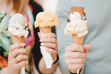 Close-up of Italian ice cream different chocolate, vanilla in hands of tourists