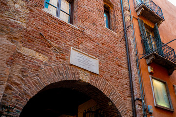 Verona, Italy - March 15, 2019: Juliet house, red locks with inscriptions and wishes on wall with chewing gum