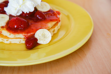 Buttermilk pancake filled with sliced banana and strawberries